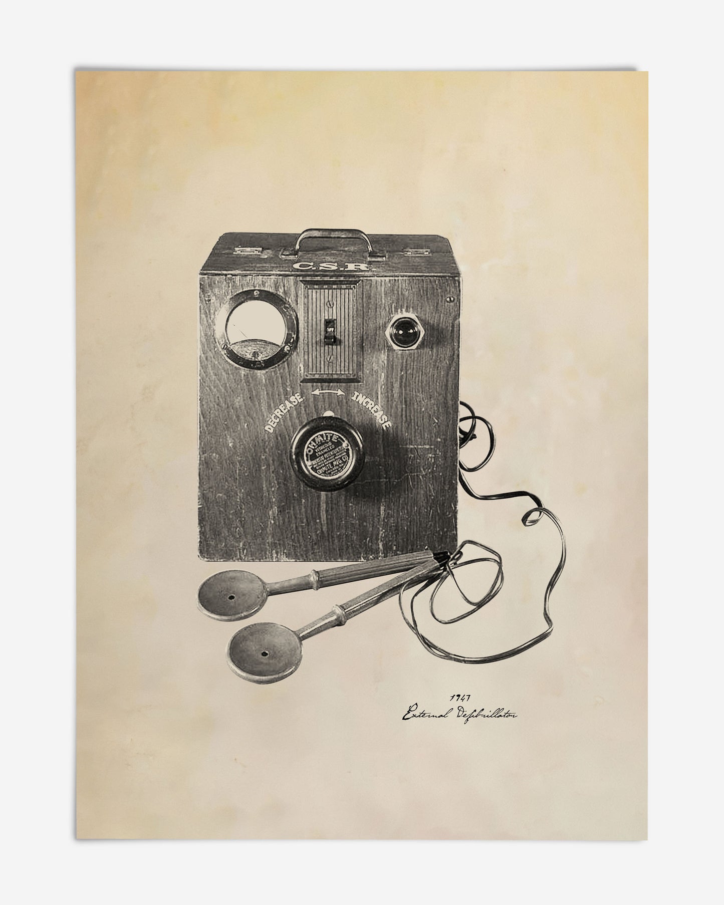 Unframed art print illustrating a 1947 external defibrillator with a wooden control box, wired paddles, and handwritten caption.