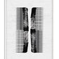 White-framed black abstract comb artwork on a textured white background.
