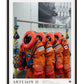Black-framed Artemis II art print showing orange crew suits hanging from a rack with NASA and flag patches.