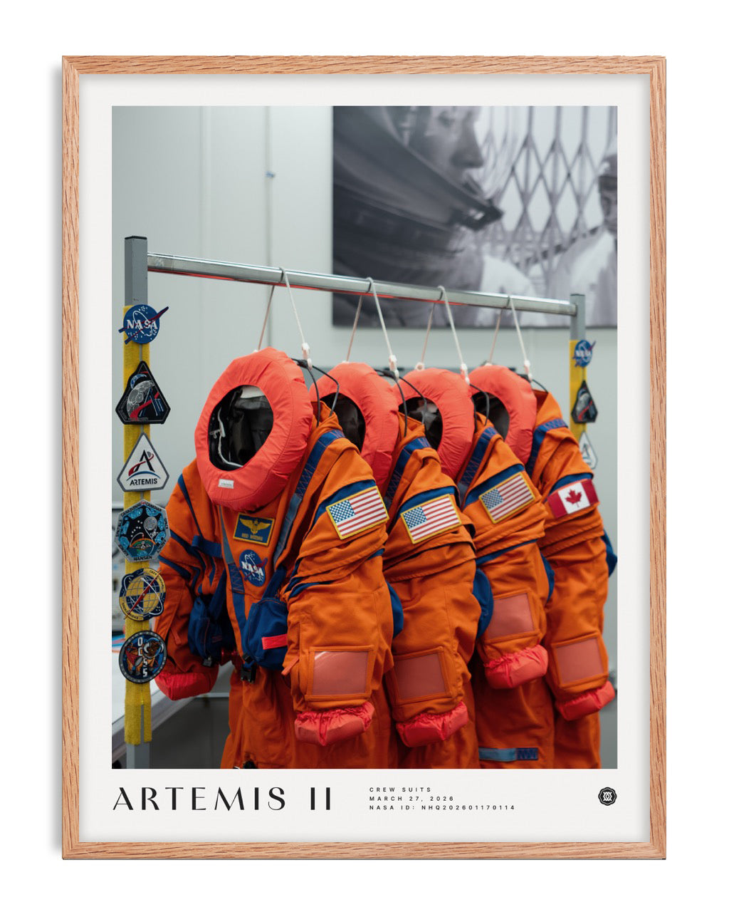 Oak-framed Artemis II art print showing five orange crew suits with NASA, United States, and Canadian patches.