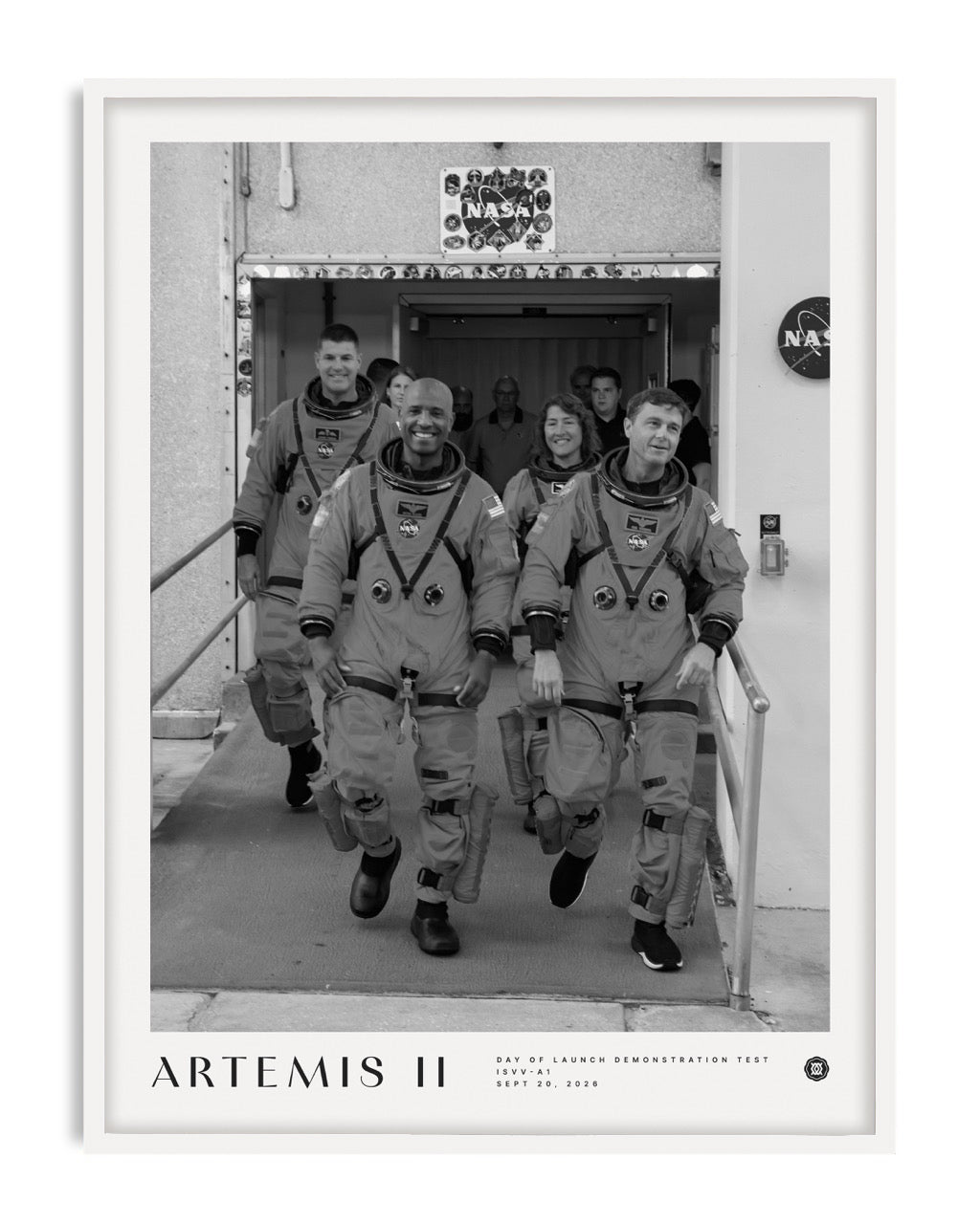 White-framed Artemis II crew art print featuring four astronauts in spacesuits walking out of a NASA building.