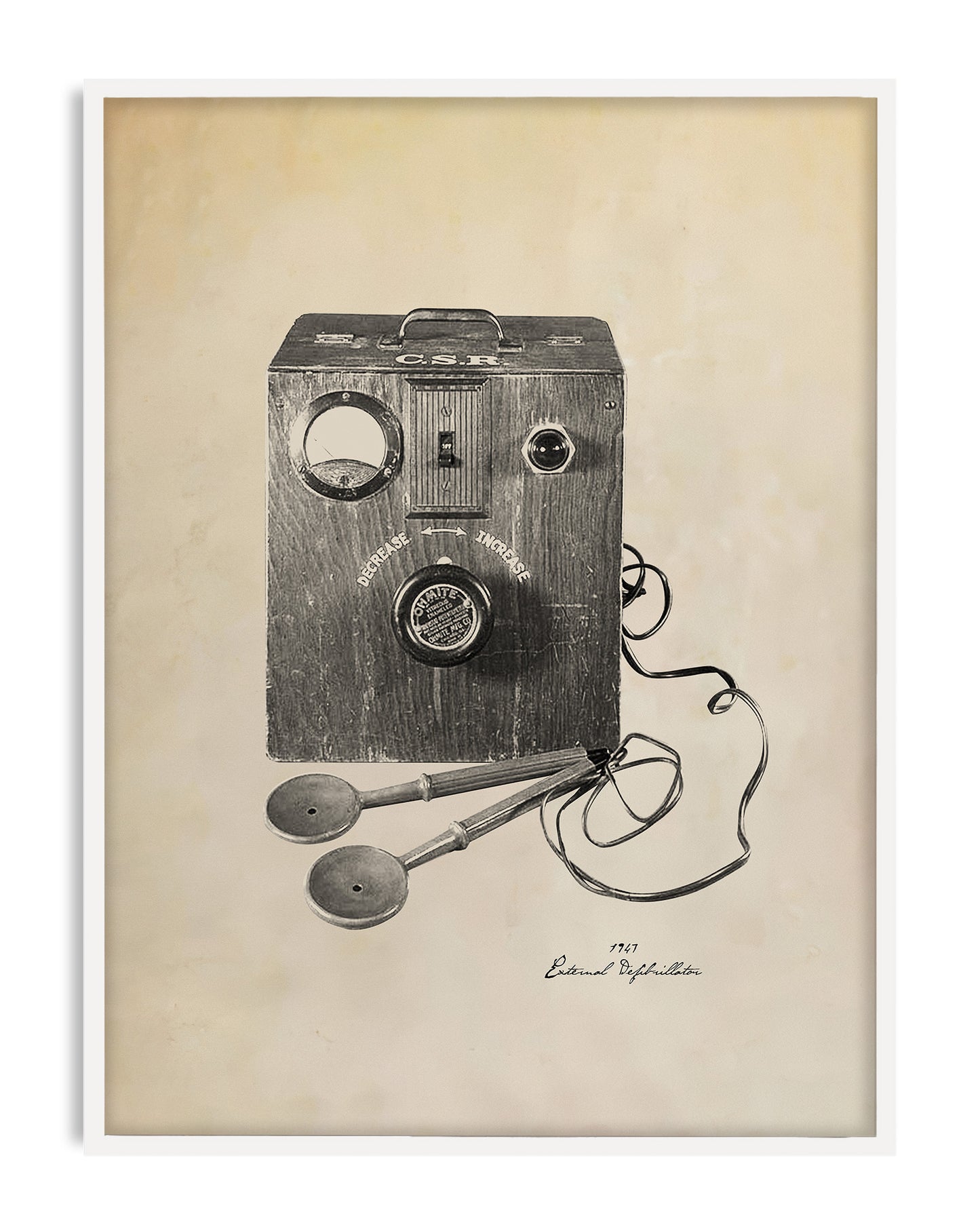White-framed art print illustrating a 1947 external defibrillator with a wooden control box and wired paddles.