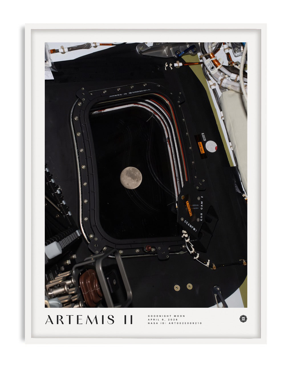 White-framed Artemis II Goodnight Moon art print showing the Moon through a spacecraft window surrounded by equipment.
