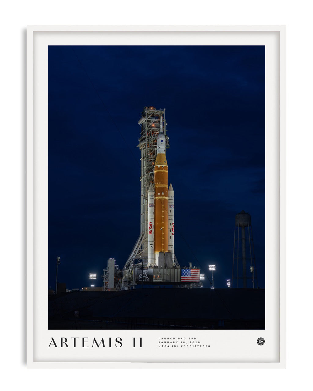 White-framed Artemis II art print showing a NASA rocket on an illuminated launch pad at night.