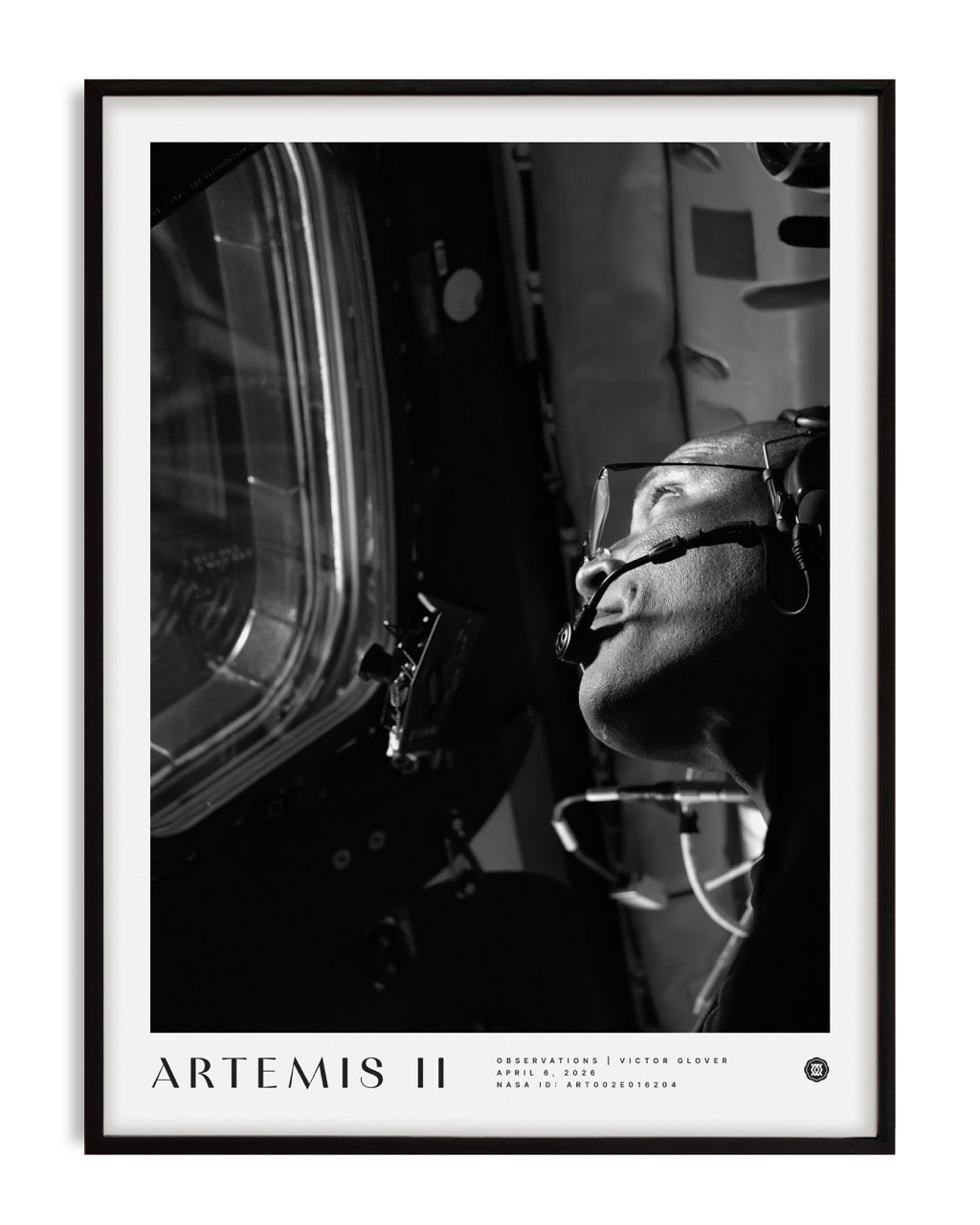 Black-framed Artemis II art print showing a black-and-white portrait of an astronaut wearing a headset and looking through a spacecraft window.