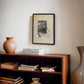 1947 defibrillator wall art print featuring a vintage medical device above bookshelf in office
