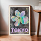 Oak-framed Tokyo 1982 Festival of the Cherry Blossoms artwork leaning on a wood floor beside a table.