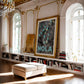 Ornate gold-framed NOLA 1857 Mardi Gras bead artwork displayed in a bright living room with arched windows and bookshelves.