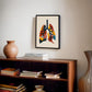 Black-framed colorful lung anatomy artwork displayed above a wooden bookcase with books and a ceramic vase.
