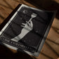 Unframed The Colorist art print lying on a wooden floor, showing a hand holding a tint brush among stars and a crescent moon.