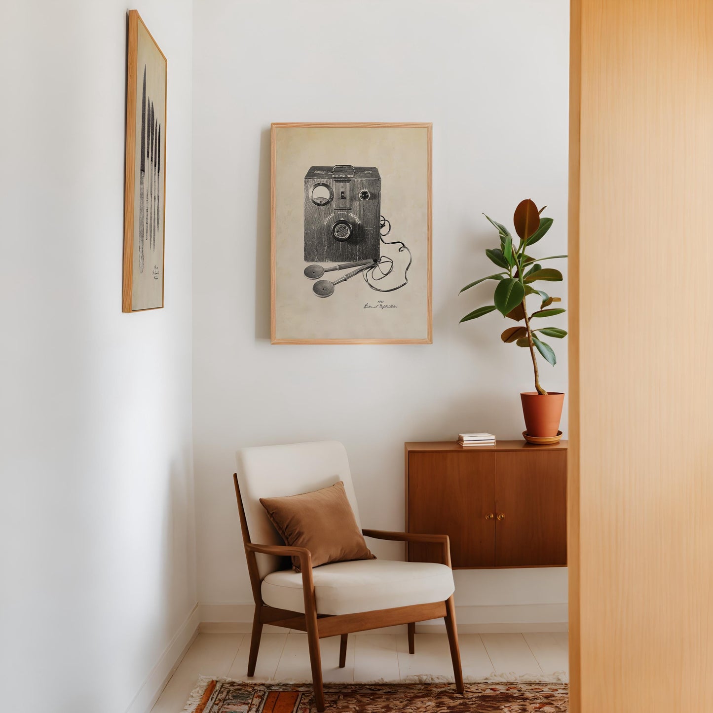 Oak-framed vintage external defibrillator artwork displayed above an armchair beside a potted plant and wooden cabinet.