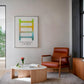 Black-framed Polyvagal Ladder diagram displayed above a rust-colored armchair and round coffee table.