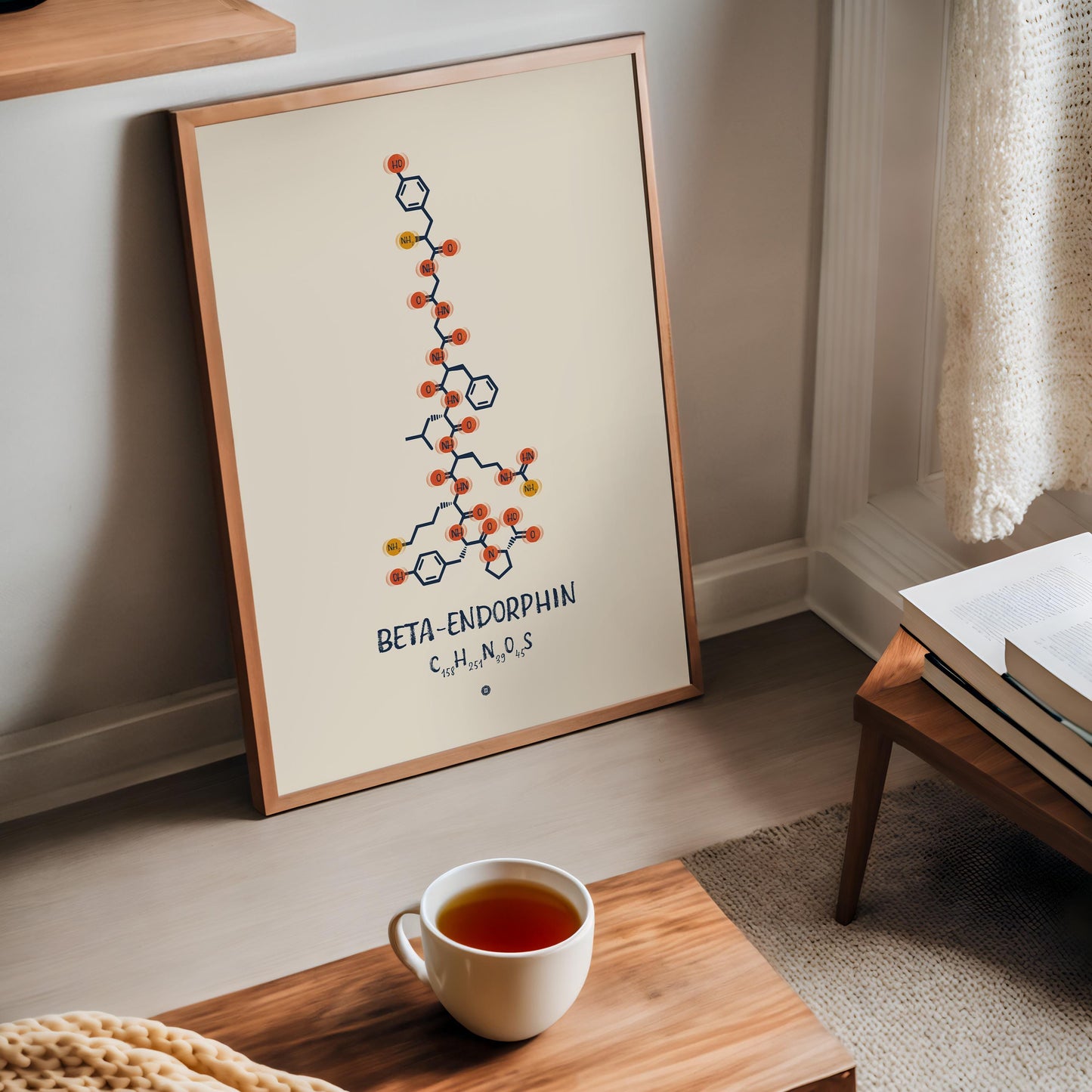 Oak-framed beta-endorphin molecular artwork leaning near a window, books, and a cup of tea.