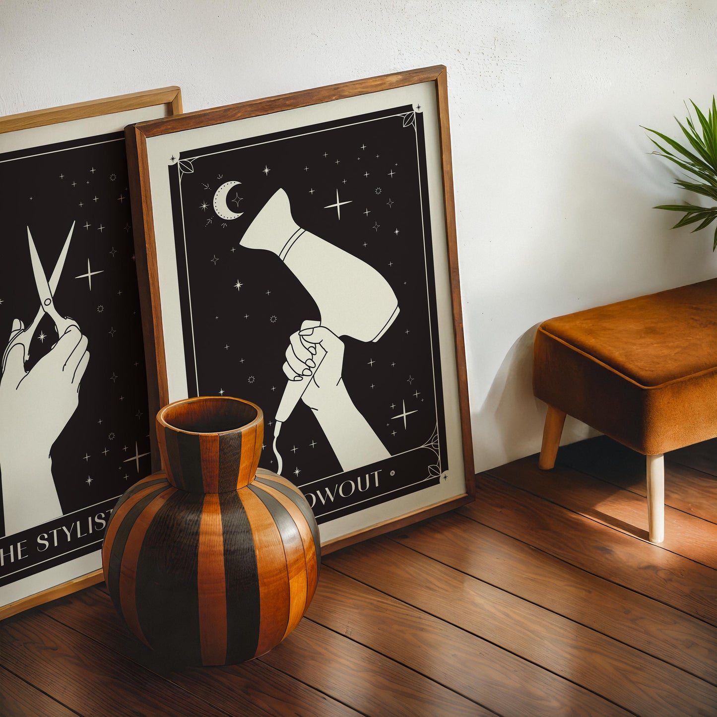 Oak-framed Blowout art print displayed beside another framed artwork, a striped wooden vase, and a stool.