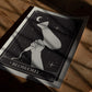 Unframed Blowout art print depicting a hand holding a hair dryer beneath a crescent moon and stars, laid on a wooden surface.