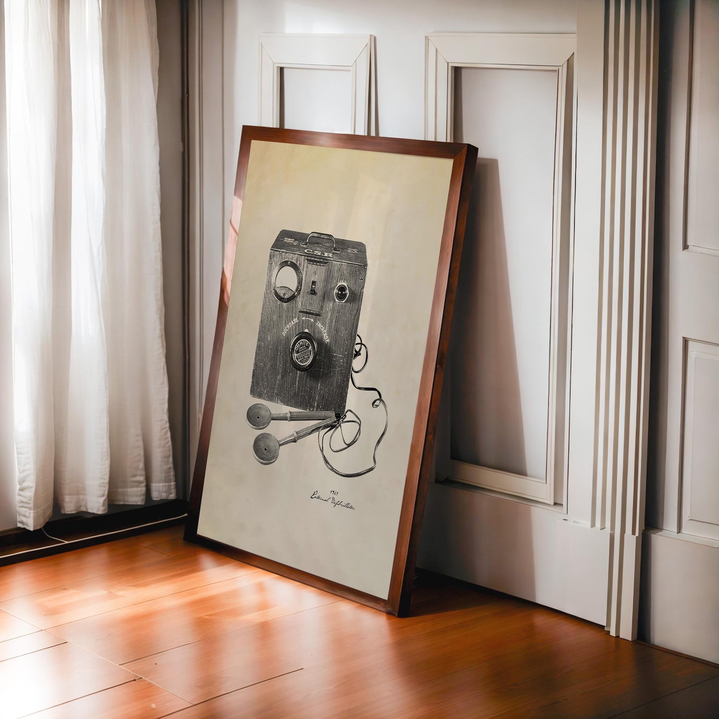 Dark wood-framed vintage external defibrillator artwork leaning against paneled walls beside a sunlit window.