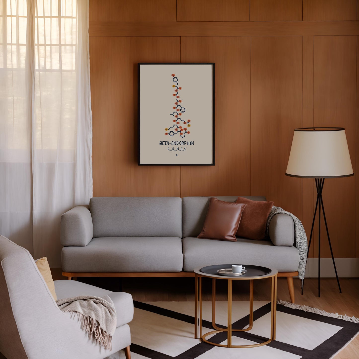 Black-framed beta-endorphin molecular artwork displayed above a gray sofa on a wood-paneled living room wall.