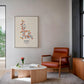Black-framed oxytocin molecular artwork displayed above a rust-colored armchair in a modern living room.