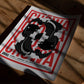 Unframed red, black, and white Chōwa koi fish art print resting on a sunlit wooden table.