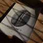 Unframed Costa Rica coffee origins art print featuring a black-and-white coffee bean lying on a sunlit wooden table.
