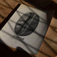 Hawaii Kona coffee bean art print lying on a wooden floor in window shadows.