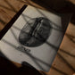 Unframed Brazil Minas Gerais coffee bean art print lying on a wooden table in patterned sunlight.