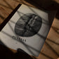 Unframed Panama Boquete coffee bean art print lying on a wooden table in patterned sunlight.