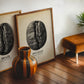 Oak-framed Panama coffee bean art print leaning on a wood floor beside a Brazil coffee artwork and striped vase.