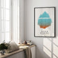 Black-framed Anger Iceberg art print displayed beside tall windows in a bright interior setting.