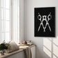 Black-framed scissors artwork hanging in a bright room above a cushioned window bench and flowers.
