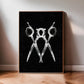 Oak-framed black and white artwork of three overlapping scissors leaning against a wall on a wood floor.
