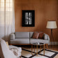Black-framed abstract comb artwork displayed above a gray sofa in a living room.