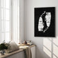 Black-framed Clippers artwork hanging beside a sunlit window and cushioned bench in a living room.