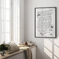Black-framed white dining-themed artwork hanging in a bright room beside tall windows.