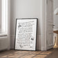 Black-framed white dining-themed artwork leaning beside a doorway in a sunlit room.