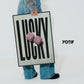 Person in jeans holding a Black-framed LUCKY art print with two pink fuzzy dice beside the YOTIF name.