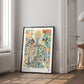 Black-framed Corporis in Bloom artwork leaning on the floor in a bright room beside a window and doorway.