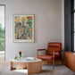 Framed YOTIF anatomy artwork with a floral rib cage, branching vessels, butterflies, and a bird displayed above a leather armchair.