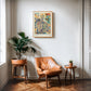 Oak-framed YOTIF anatomy art print with a floral rib cage, branching vessels, butterflies, and a bird above a tan leather chair.