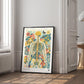 Black-framed floral anatomy artwork leaning against a wall in a bright room with decorative molding.