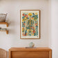 Framed floral anatomy artwork displayed above a console table with a ceramic vase.