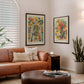 Two Black-framed anatomical artworks displayed above a tan leather sofa in a living room.