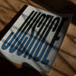 Unframed JUSTICE typography art print lying on a wooden floor beneath leafy shadows