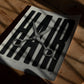 Unframed HAIR art print with silver scissors lying on a sunlit wooden table.