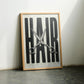Oak-framed HAIR artwork with silver scissors leaning on the floor between two chairs.