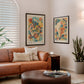 Black-framed Auris in Bloom artwork displayed beside another anatomical art print above a leather sofa.