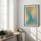 Black-framed teal and yellow abstract “Get back to center” art print hanging in a sunlit bedroom.