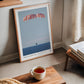 Light wood-framed Artemis II Orion capsule recovery art print leaning near a window and a table with a cup of tea.