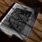 Unframed Artemis II crew art print lying on a wooden table in dappled sunlight.