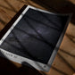 Unframed Artemis II Starstruck art print lying on a wooden table in dramatic sunlight and shadow.
